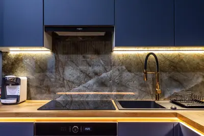 a kitchen with a sink and blue cabinets at RentPlanet - Apartamenty Kościuszki in Kraków