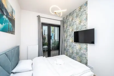 a bedroom with a bed and a flat screen tv at RentPlanet - Apartamenty Kościuszki in Kraków