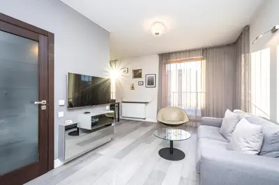 a living room with a couch and a tv at RentPlanet - Apartament Lubicz in Kraków