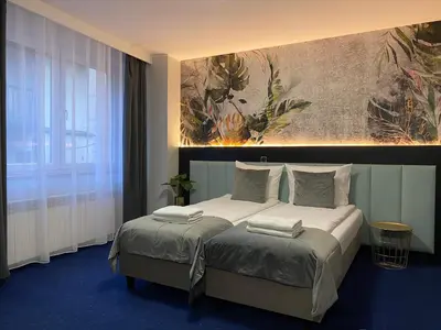 a bedroom with a bed with a painting on the wall at Cube House Aparthotel in Kraków