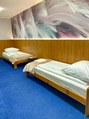 two beds in a room with a painting on the wall at Cube House Aparthotel in Kraków