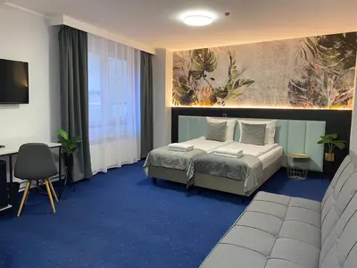 a bedroom with a bed and a desk in a room at Cube House Aparthotel in Kraków