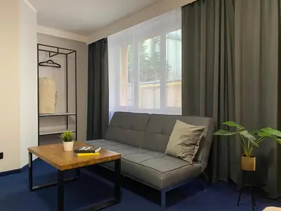 a living room with a couch and a table at Cube House Aparthotel in Kraków