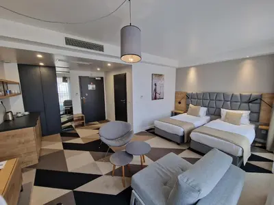 a hotel room with two beds and a living room at Apartament 338 ulica Lwowska 1 in Kraków