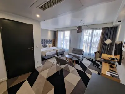 a hotel room with a bed and a living room at Apartament 338 ulica Lwowska 1 in Kraków