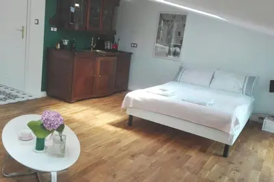 a living room with a bed and a table with flowers at Z widokiem- Old Town in Kraków