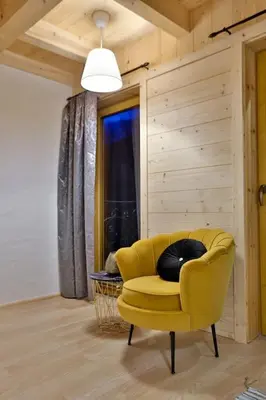 a yellow chair sitting in a room with a window at Dom na Zapotoczu. Góralski dom na wyłączność na szczycie skały. in Kasinka Mala