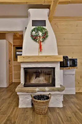 a living room with a fireplace with a wreath on it at Dom na Zapotoczu. Góralski dom na wyłączność na szczycie skały. in Kasinka Mala