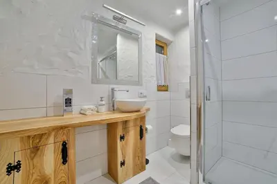 a bathroom with a sink and a toilet and a mirror at Dom na Zapotoczu. Góralski dom na wyłączność na szczycie skały. in Kasinka Mala