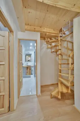 a room with a wooden spiral staircase in a house at Dom na Zapotoczu. Góralski dom na wyłączność na szczycie skały. in Kasinka Mala