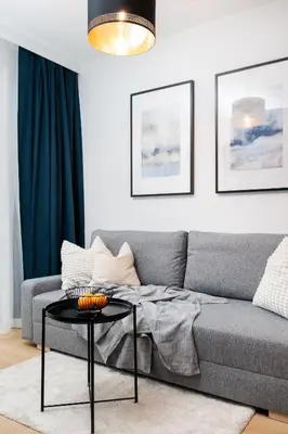 a living room with a gray couch and a table at Colorful Cracovia Apartments - by Upstairs in Kraków
