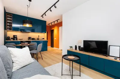 a living room with a couch and a tv at Colorful Cracovia Apartments - by Upstairs in Kraków