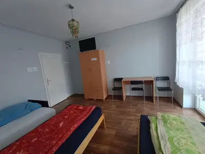 a bedroom with a bed and a desk and a table at Noclegi nad S-ką in Miechów