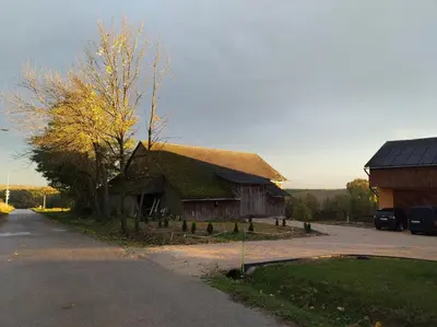 a large building with a pitched roof and a parking lot at Noclegi nad S-ką in Miechów