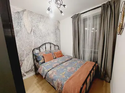 a bedroom with a bed and a large window at Nowe mieszkanie Kraków, bezpłatny parking, AWG APARTMENTS in Kraków