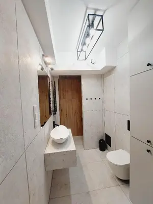 a white bathroom with a toilet and a sink at Nowe mieszkanie Kraków, bezpłatny parking, AWG APARTMENTS in Kraków