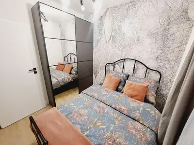 a small bedroom with a bed and a mirror at Nowe mieszkanie Kraków, bezpłatny parking, AWG APARTMENTS in Kraków