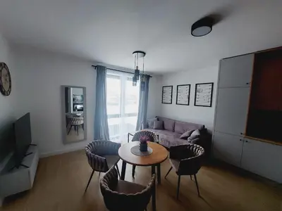 a living room with a couch and a table and chairs at Nowe mieszkanie Kraków, bezpłatny parking, AWG APARTMENTS in Kraków