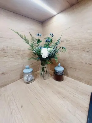 a vase with blue and white flowers on a table at Nowe mieszkanie Kraków, bezpłatny parking, AWG APARTMENTS in Kraków