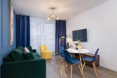 a living room with a green couch and a table at Blue and Green Apartment with Bright Pink Bedroom in Kraków by Noclegi Renters in Kraków