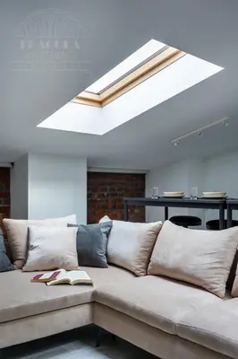 a couch in a living room with a skylight at Spacious apartment 11 PAX, Vistula River - Fragola Apartments in Kraków