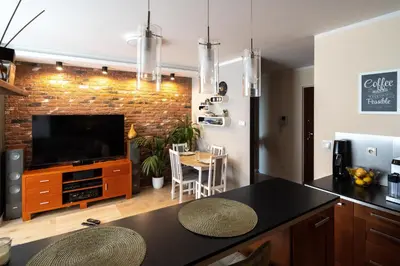 a kitchen and dining room with a brick wall at Verona Apartament 115, 69m2, Terrace, Garage in Kraków