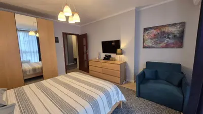 a bedroom with a bed and a blue chair at Verona Apartament 115, 69m2, Terrace, Garage in Kraków