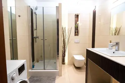a bathroom with a shower and a toilet and a sink at Verona Apartament 115, 69m2, Terrace, Garage in Kraków