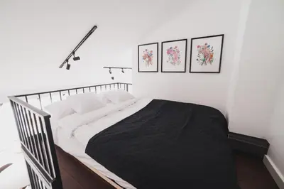 a bed in a bedroom with three pictures on the wall at Vitrum Apartments in Kraków