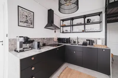 a kitchen with black cabinets and a counter top at Vitrum Apartments in Kraków