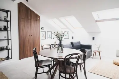 a living room with a table and chairs and a couch at Vitrum Apartments in Kraków