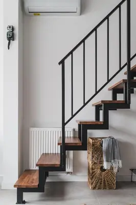 a black staircase with wooden steps and a basket at Vitrum Apartments in Kraków