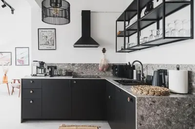 a kitchen with black cabinets and a counter at Vitrum Apartments in Kraków