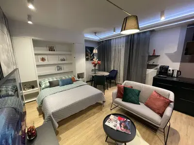 a bedroom with a bed and a couch and a table at New comfortable apartment with balcony and sauna on Klimieckiego street in Kraków