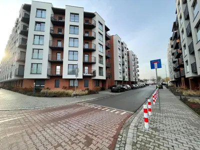 an empty street in front of a tall building at New comfortable apartment with balcony and sauna on Klimieckiego street in Kraków