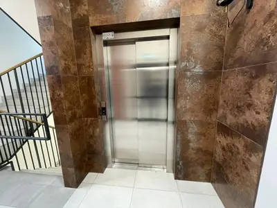 an elevator in a building with a staircase at New comfortable apartment with balcony and sauna on Klimieckiego street in Kraków