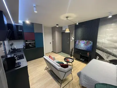 a living room with a couch and a tv at New comfortable apartment with balcony and sauna on Klimieckiego street in Kraków
