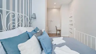 a bedroom with a bed with blue and white pillows at Bogusławskiego , Sun & Snow in Kraków