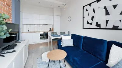 a living room with a blue couch and a kitchen at Bogusławskiego , Sun & Snow in Kraków