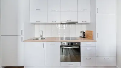 a white kitchen with white cabinets and a sink at Bogusławskiego , Sun & Snow in Kraków