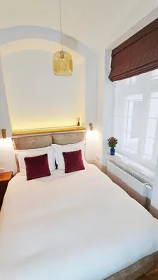 a bedroom with a large white bed with two red pillows at Deluxe Vintage Chic Apartment - Kazimierz Old Town in Kraków