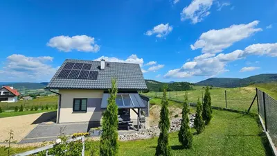 a house with solar panels on the roof at BliżejGorców in Lubomierz