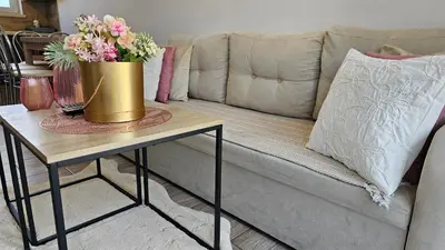 a couch with a table with a pot of flowers on it at BliżejGorców in Lubomierz