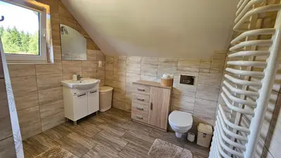 a bathroom with a sink and a toilet and a staircase at BliżejGorców in Lubomierz