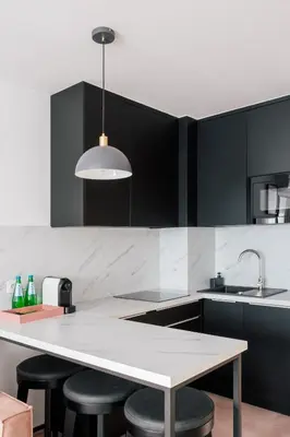 a kitchen with a table and some black cabinets at Home From Home - Kraków, Podgórze in Kraków