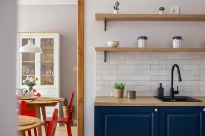 a kitchen with blue cabinets and a sink and a table at Prandoty Beautiful Apartment with Balcony Cracow by Renters Prestige in Kraków