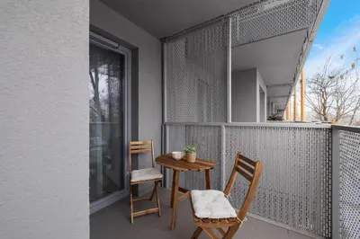 a balcony with two chairs and a table and a window at Prandoty Beautiful Apartment with Balcony Cracow by Renters Prestige in Kraków