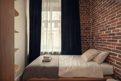 a bed in a room with a brick wall at Austin Flowers Old Town by WillyWalls in Kraków