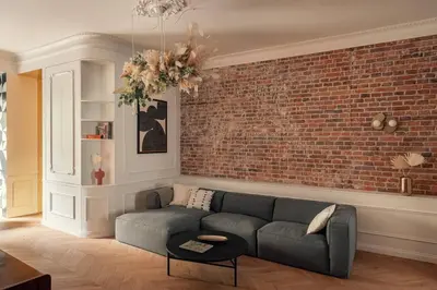 a living room with a couch and a brick wall at Austin Flowers Old Town by WillyWalls in Kraków