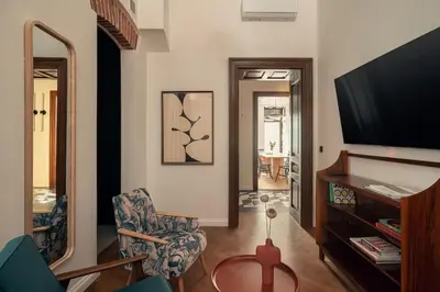 a living room with a tv and a chair at Austin Flowers Old Town by WillyWalls in Kraków